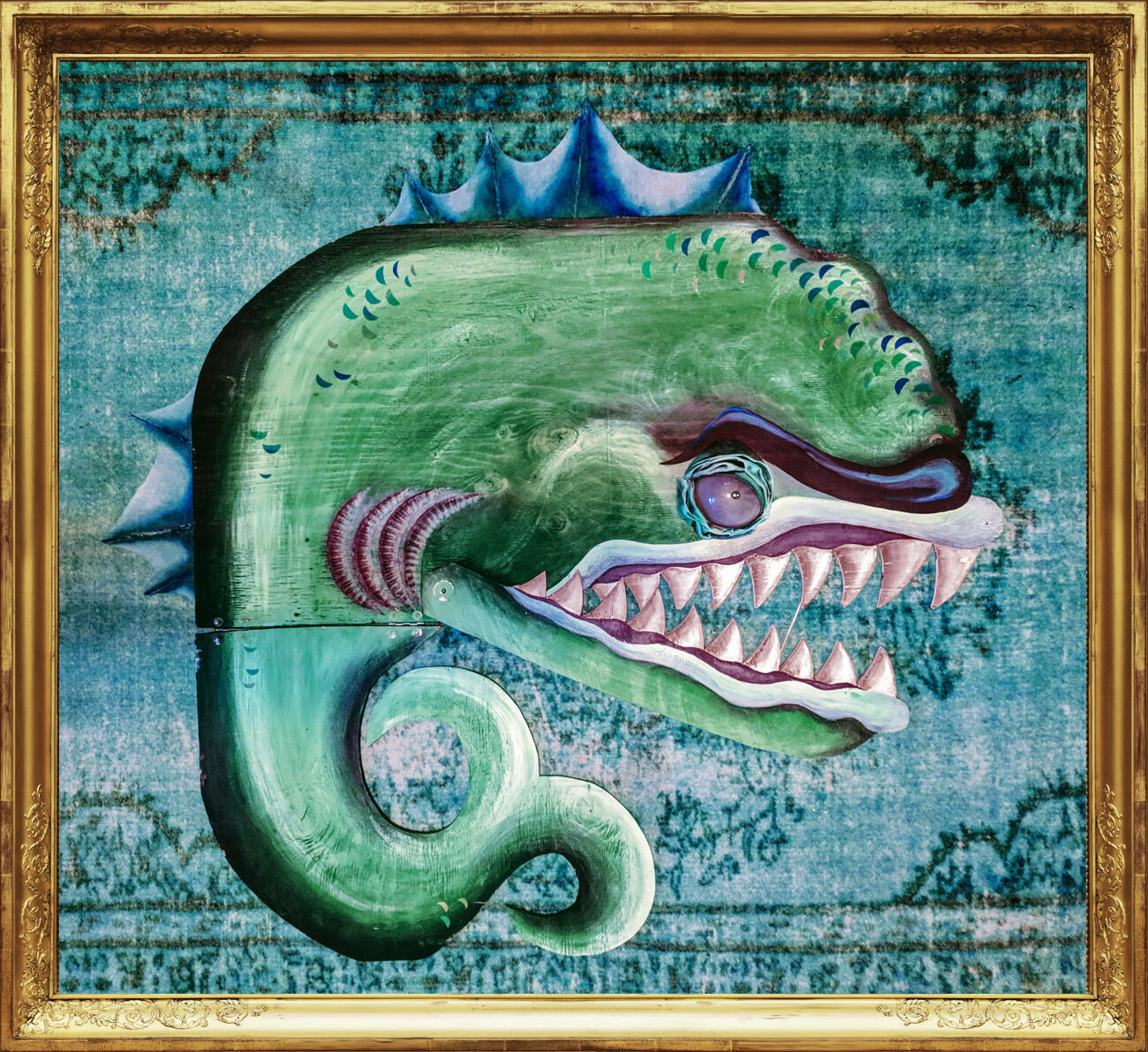 Large plywood theater puppet shaped like a turn-of-the-century sea monster, with iridescent scales, spiked fins, hinged jaw, and a glowing eye.