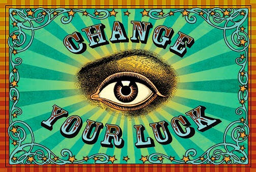 Fortune Teller's Card A card that reads "change your luck" in vintage circus style lettering, a vintage illustration of an eye with golden and turquoise rays and a striped border in orange and yellow with swirls and stars